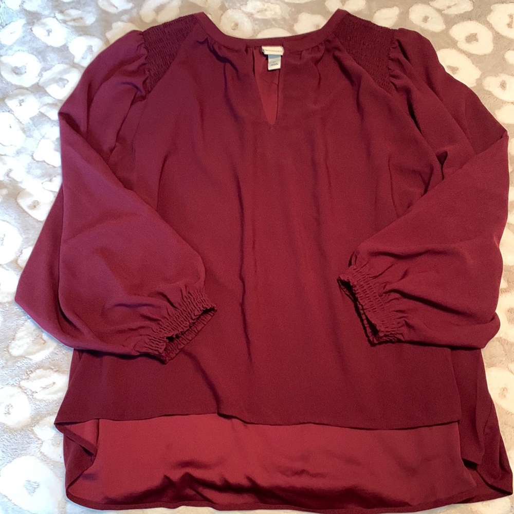 slight  v neck maroon blouse with elastic cuffed sleeves.